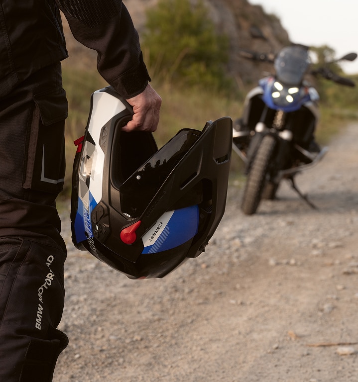 Ένα άτομο κρατάει ένα κράνος μοτοσικλέτας στο χέρι του.